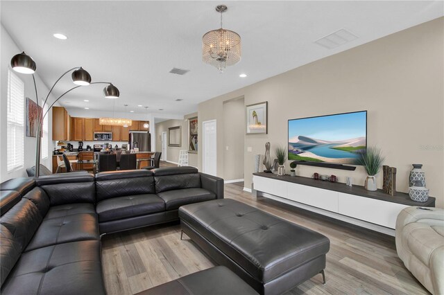 living room featuring wood-type flooring and an inviting chandelier