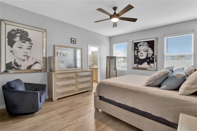 bedroom featuring light wood-type flooring, ensuite bathroom, and ceiling fan