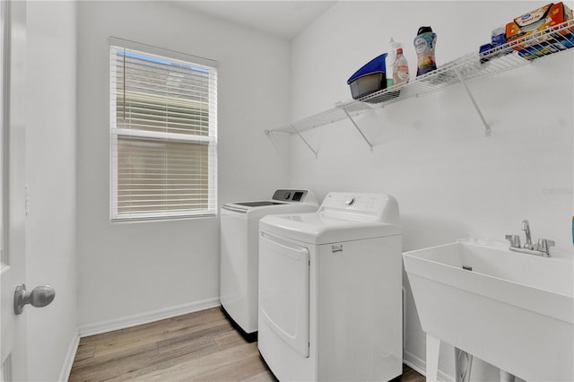 washroom with washer and clothes dryer, sink, and light wood-type flooring