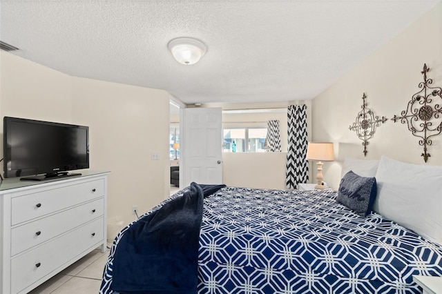 tiled bedroom featuring a textured ceiling