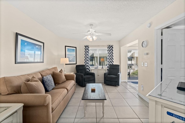 tiled living room with a textured ceiling and ceiling fan