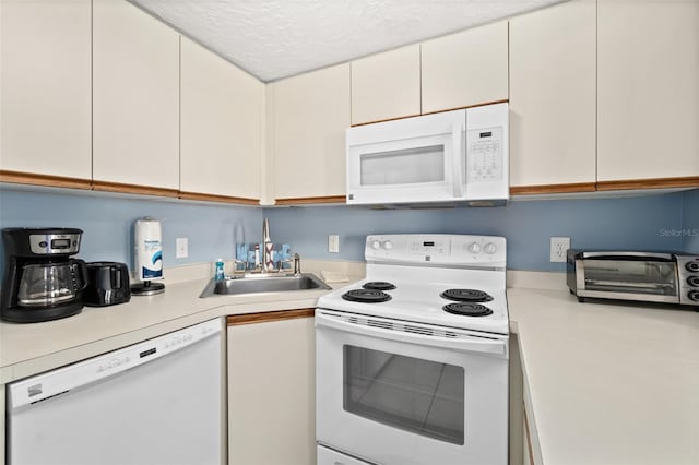 kitchen featuring white cabinets, a textured ceiling, white appliances, and sink