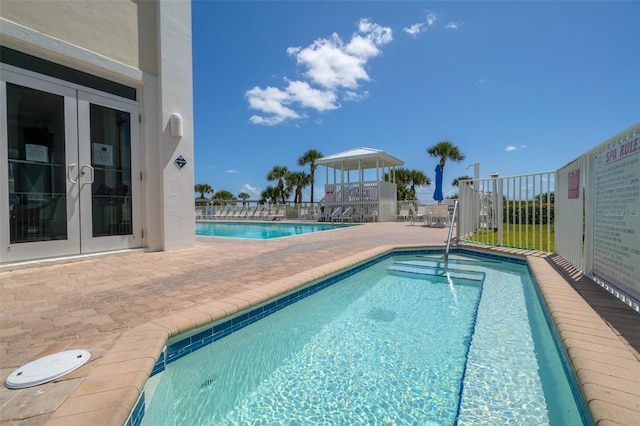 view of swimming pool with french doors and a patio