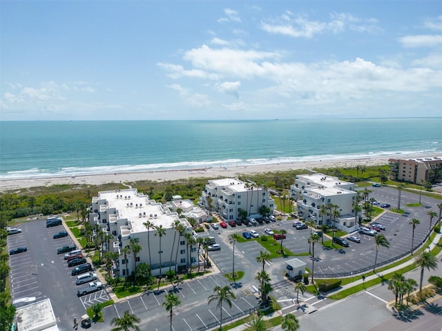 drone / aerial view featuring a water view and a beach view