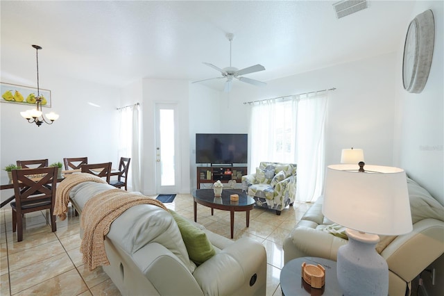 living room with ceiling fan with notable chandelier and light tile patterned floors