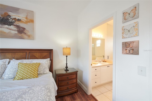 bedroom featuring connected bathroom, sink, and wood-type flooring