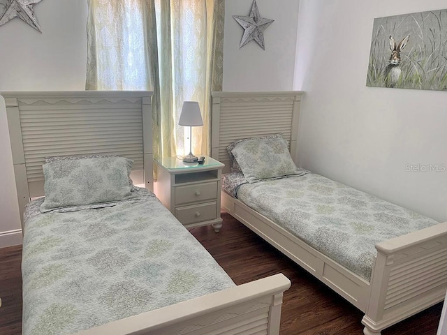 bedroom with dark hardwood / wood-style flooring