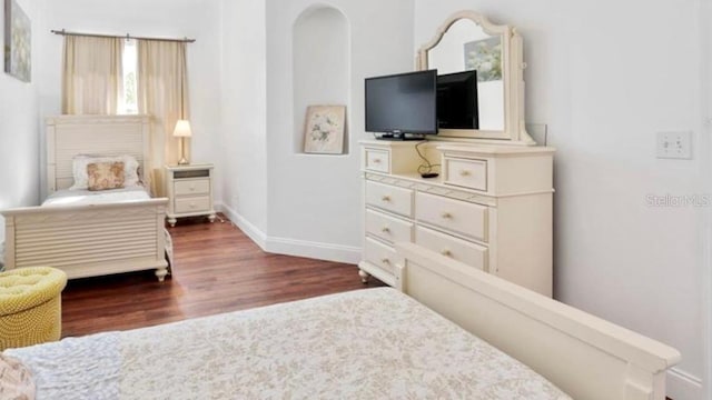 bedroom with dark hardwood / wood-style flooring