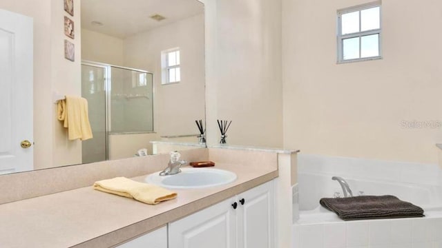 bathroom with a wealth of natural light, vanity, and shower with separate bathtub