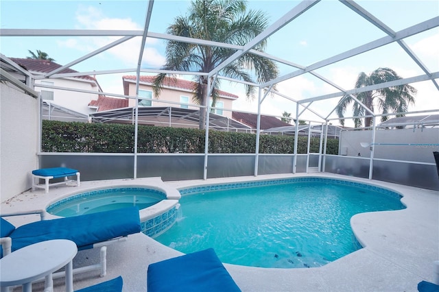 view of swimming pool featuring glass enclosure and an in ground hot tub