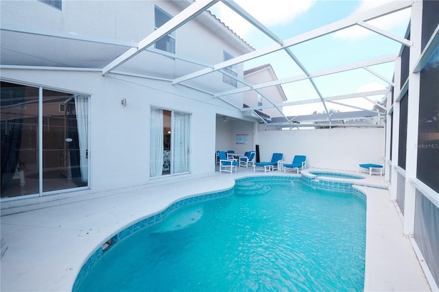 view of swimming pool with a lanai, a patio area, and an in ground hot tub