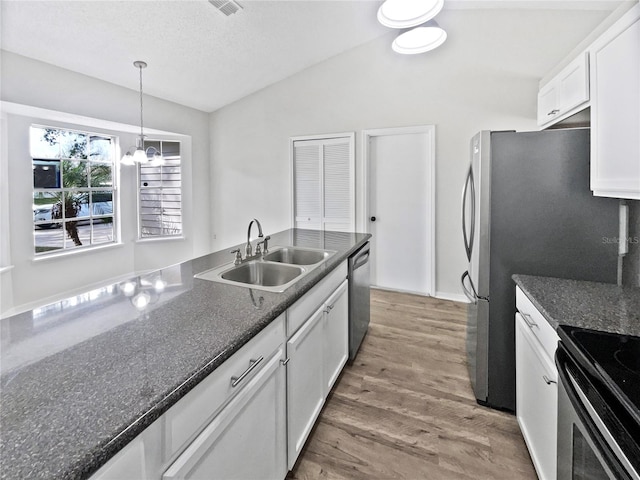 kitchen featuring dishwasher, an inviting chandelier, hardwood / wood-style floors, vaulted ceiling, and white cabinets