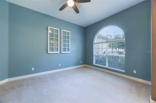 carpeted spare room featuring ceiling fan