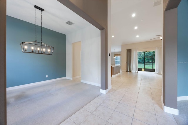 interior space featuring light carpet and ceiling fan with notable chandelier