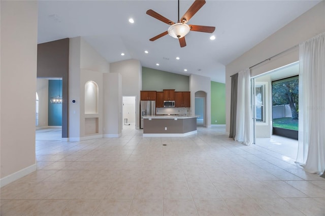 unfurnished living room with ceiling fan, light tile patterned flooring, and high vaulted ceiling