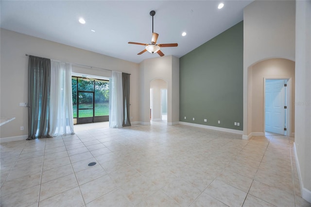 tiled spare room featuring a high ceiling and ceiling fan