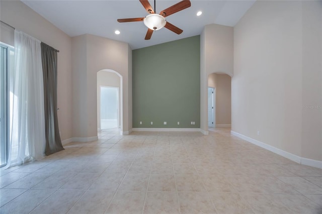 tiled empty room featuring high vaulted ceiling, plenty of natural light, and ceiling fan