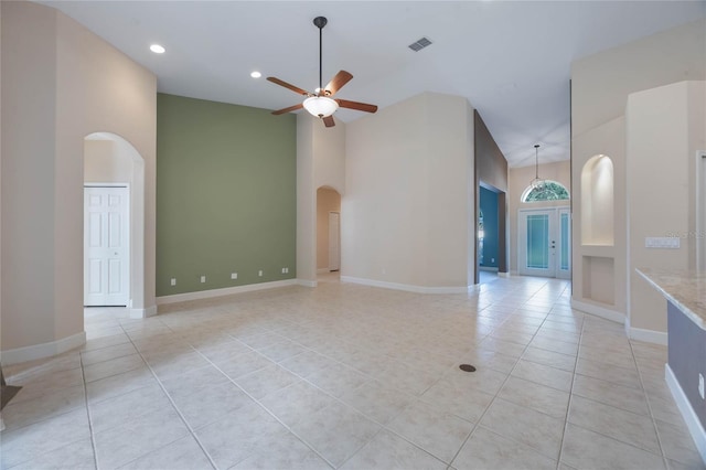 spare room featuring ceiling fan, a towering ceiling, and light tile patterned floors