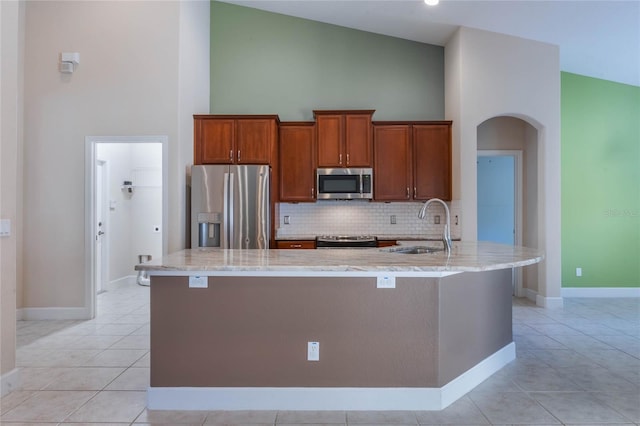 kitchen featuring appliances with stainless steel finishes, high vaulted ceiling, a large island, and sink