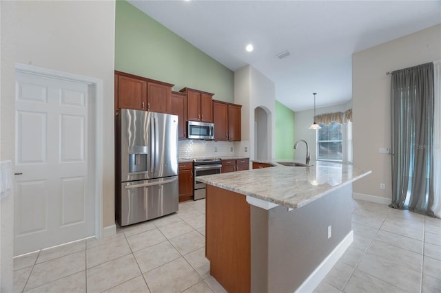 kitchen with light stone countertops, stainless steel appliances, a kitchen island with sink, sink, and lofted ceiling