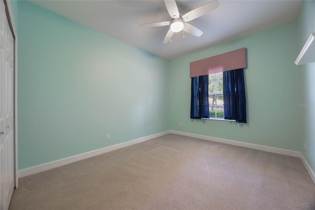 carpeted spare room with ceiling fan