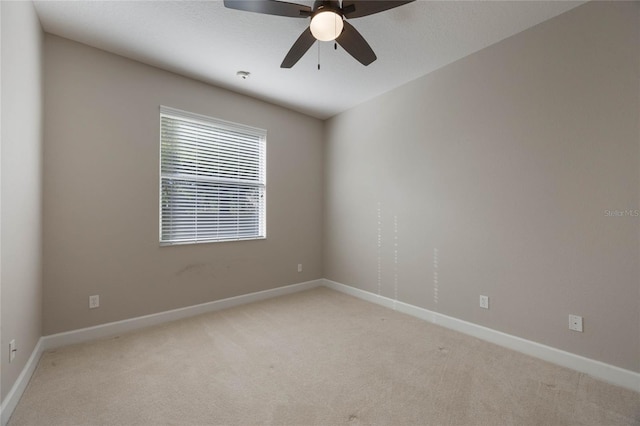 spare room featuring ceiling fan and light colored carpet