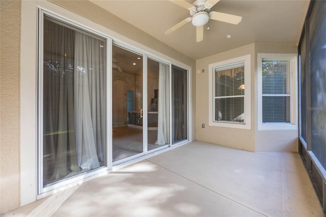 unfurnished sunroom featuring ceiling fan