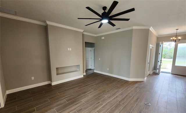 spare room with ceiling fan with notable chandelier, dark wood-type flooring, visible vents, baseboards, and ornamental molding