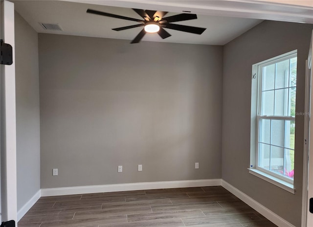 empty room featuring a ceiling fan, wood finish floors, visible vents, and baseboards