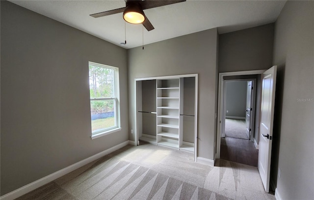 unfurnished bedroom featuring baseboards, a ceiling fan, and light colored carpet