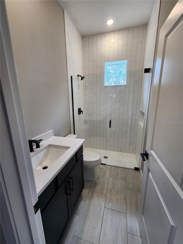 full bathroom featuring toilet, a shower stall, recessed lighting, and vanity