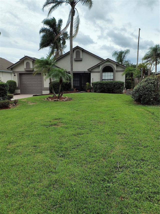 ranch-style house featuring a front lawn and a garage