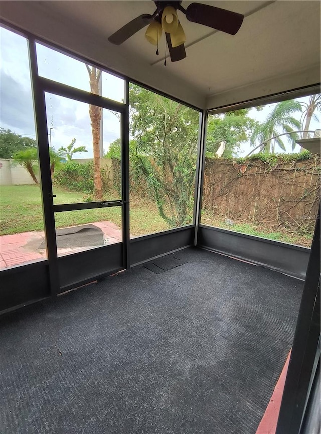 unfurnished sunroom with ceiling fan