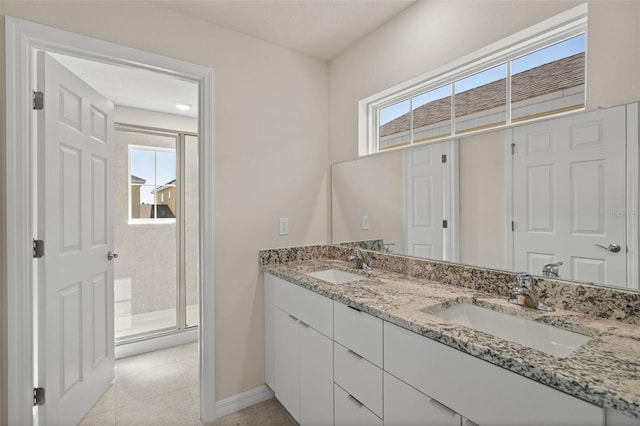 bathroom featuring tile patterned flooring, vanity, a shower with shower door, and a wealth of natural light