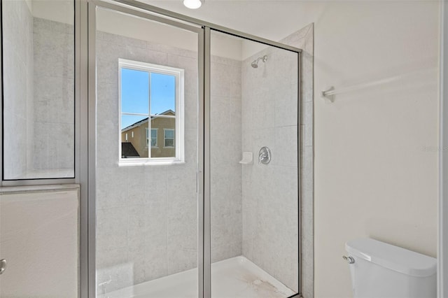 bathroom with toilet and a shower with shower door