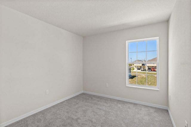 carpeted empty room featuring a textured ceiling