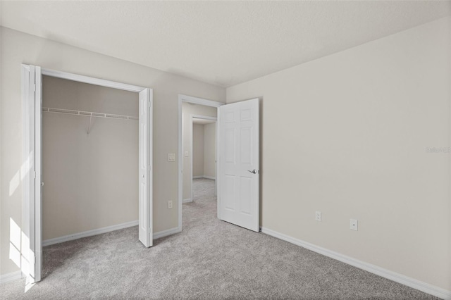 unfurnished bedroom featuring light colored carpet and a closet