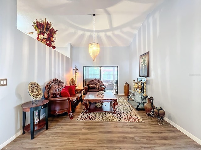 living area with hardwood / wood-style floors, high vaulted ceiling, and a chandelier