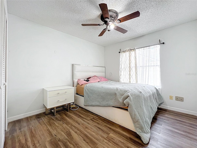 bedroom featuring wood-type flooring, a textured ceiling, and ceiling fan