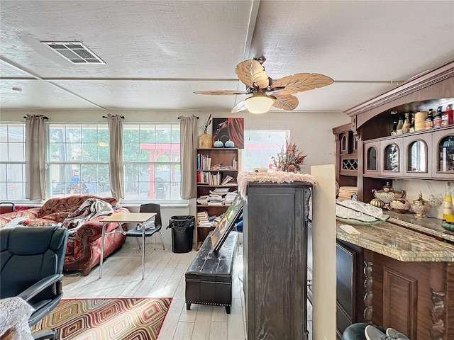 office with light wood-type flooring and ceiling fan