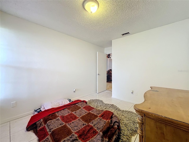 bedroom with light tile patterned floors and a textured ceiling