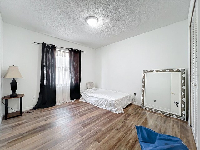 bedroom with wood-type flooring and a textured ceiling