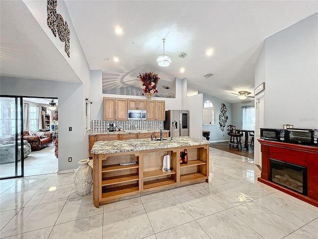 kitchen with stainless steel appliances, a kitchen island with sink, a healthy amount of sunlight, and ceiling fan