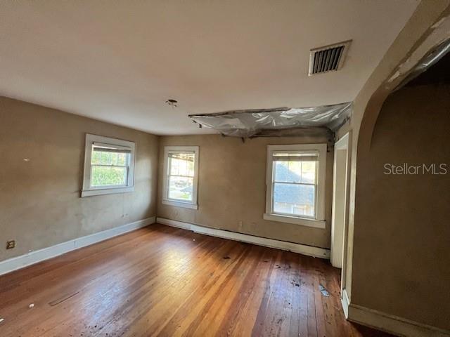 unfurnished room with a healthy amount of sunlight and wood-type flooring