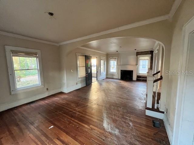 unfurnished living room with dark hardwood / wood-style floors and ornamental molding