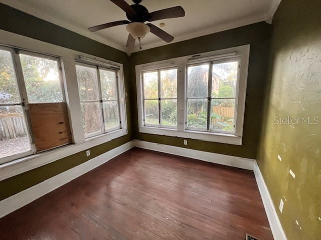 unfurnished sunroom with ceiling fan