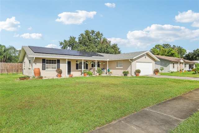 single story home with solar panels, a garage, covered porch, and a front yard