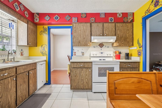 kitchen featuring sink, backsplash, a textured ceiling, white appliances, and light tile patterned floors