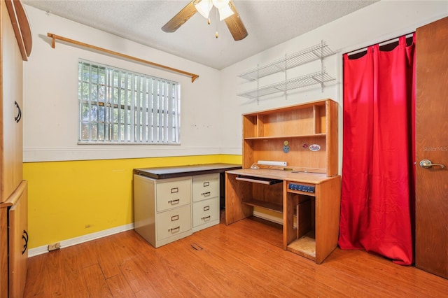 unfurnished office featuring a textured ceiling, light hardwood / wood-style floors, and ceiling fan