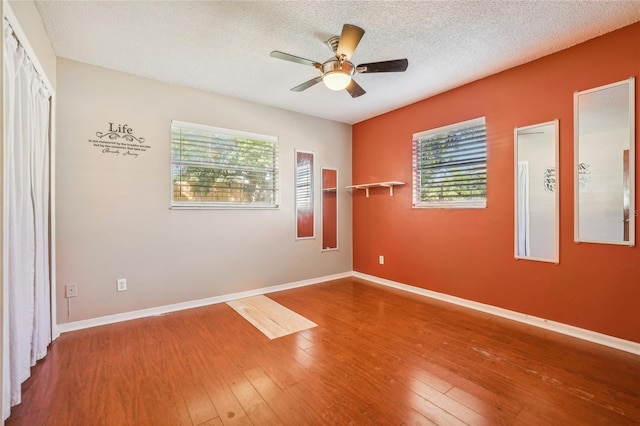 spare room with a textured ceiling, hardwood / wood-style flooring, and ceiling fan